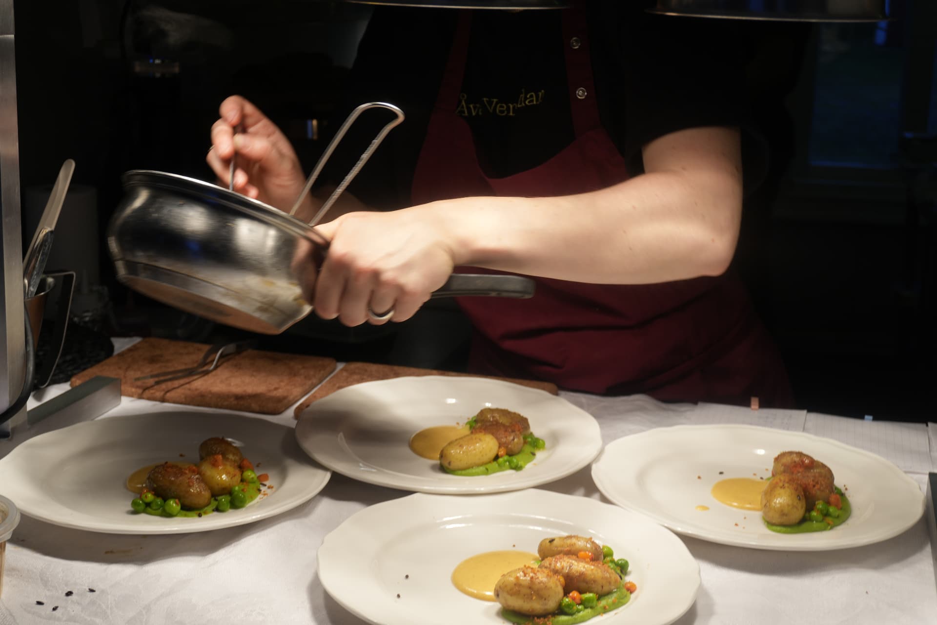 Plating four dishes at the pass during service